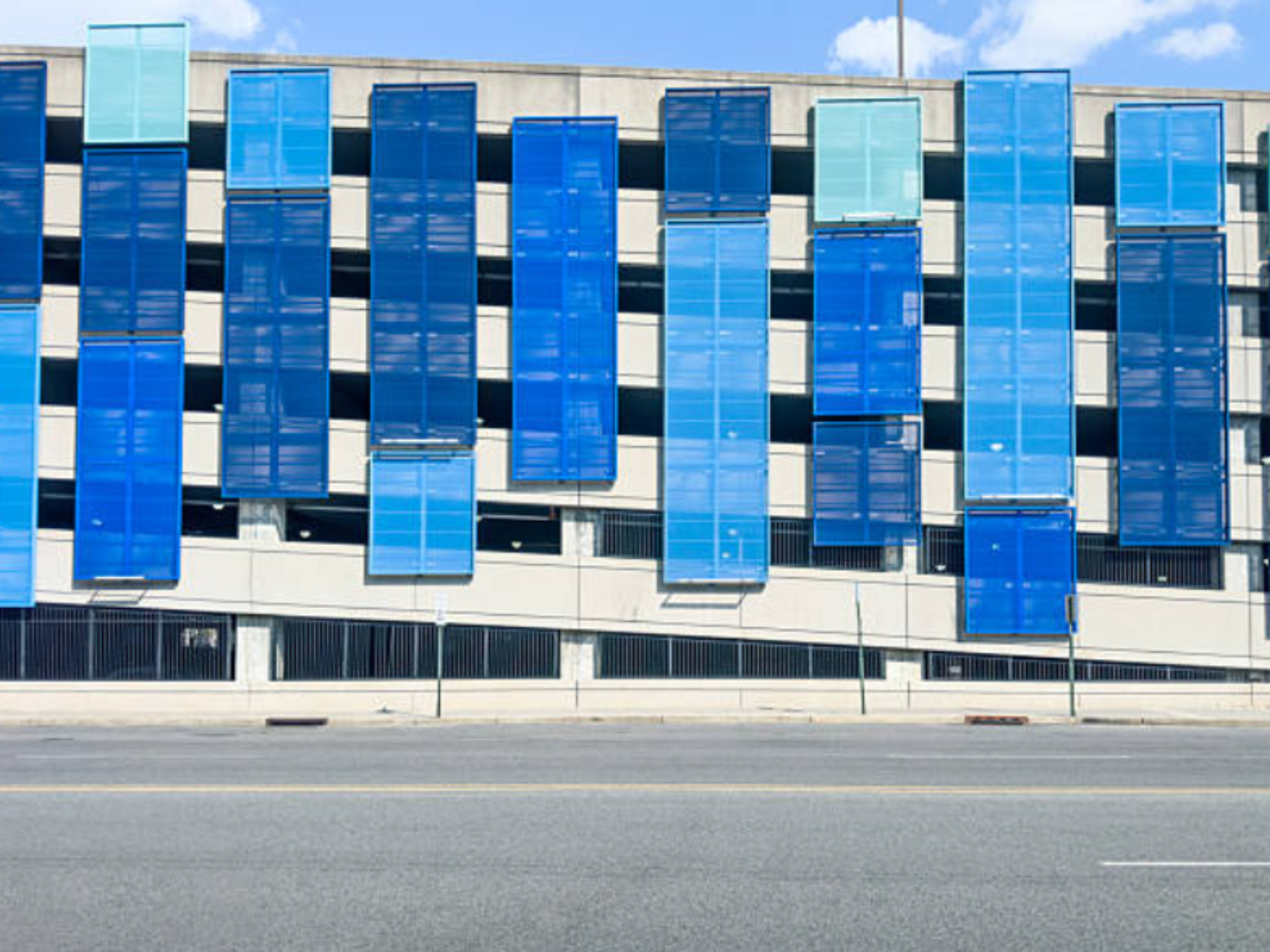 Parking structure facade featuring blue Metal Shadowbox panels mounted across multiple levels.