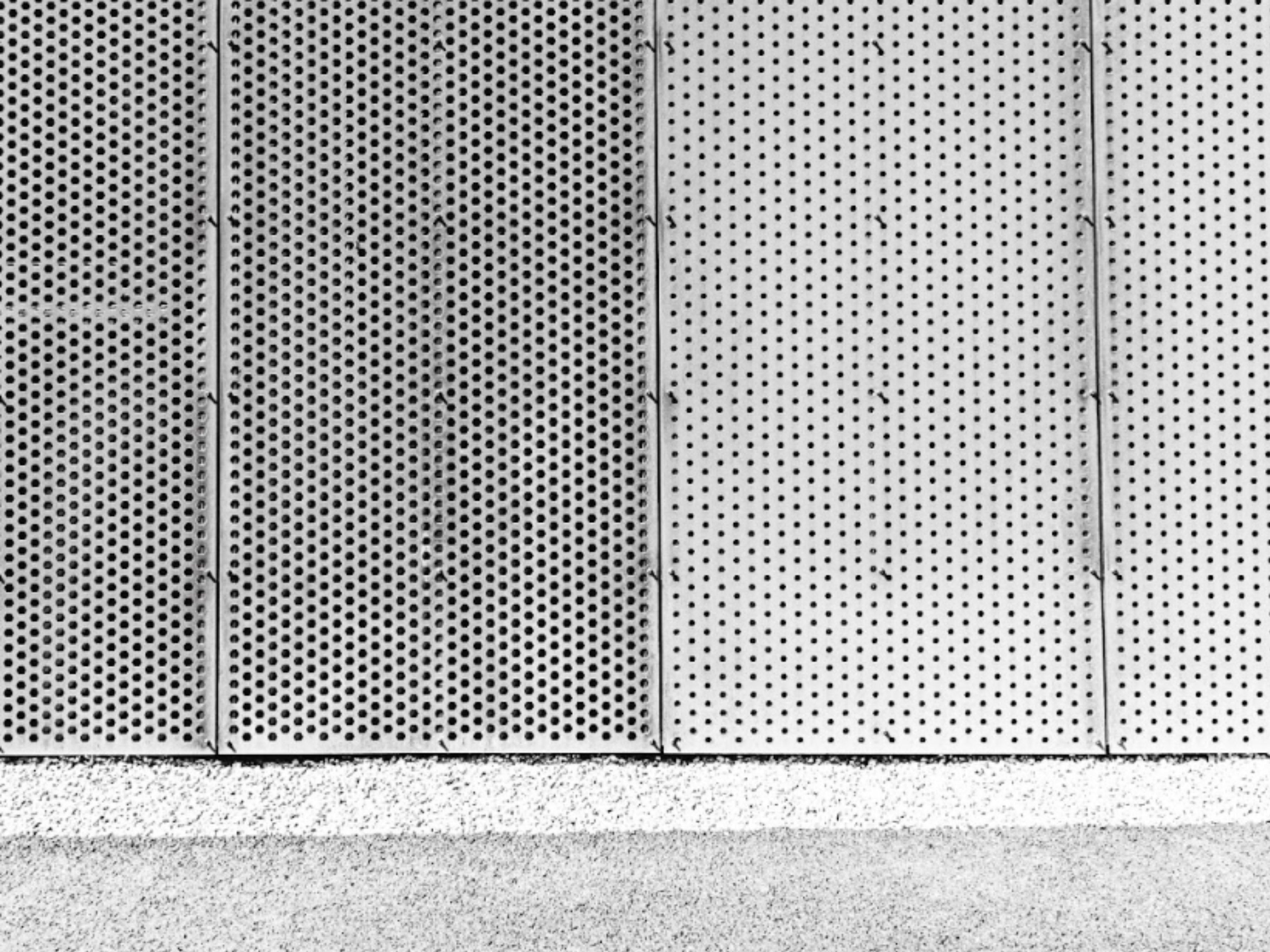 Close up view of perf metal panels with uniform circular perforations.