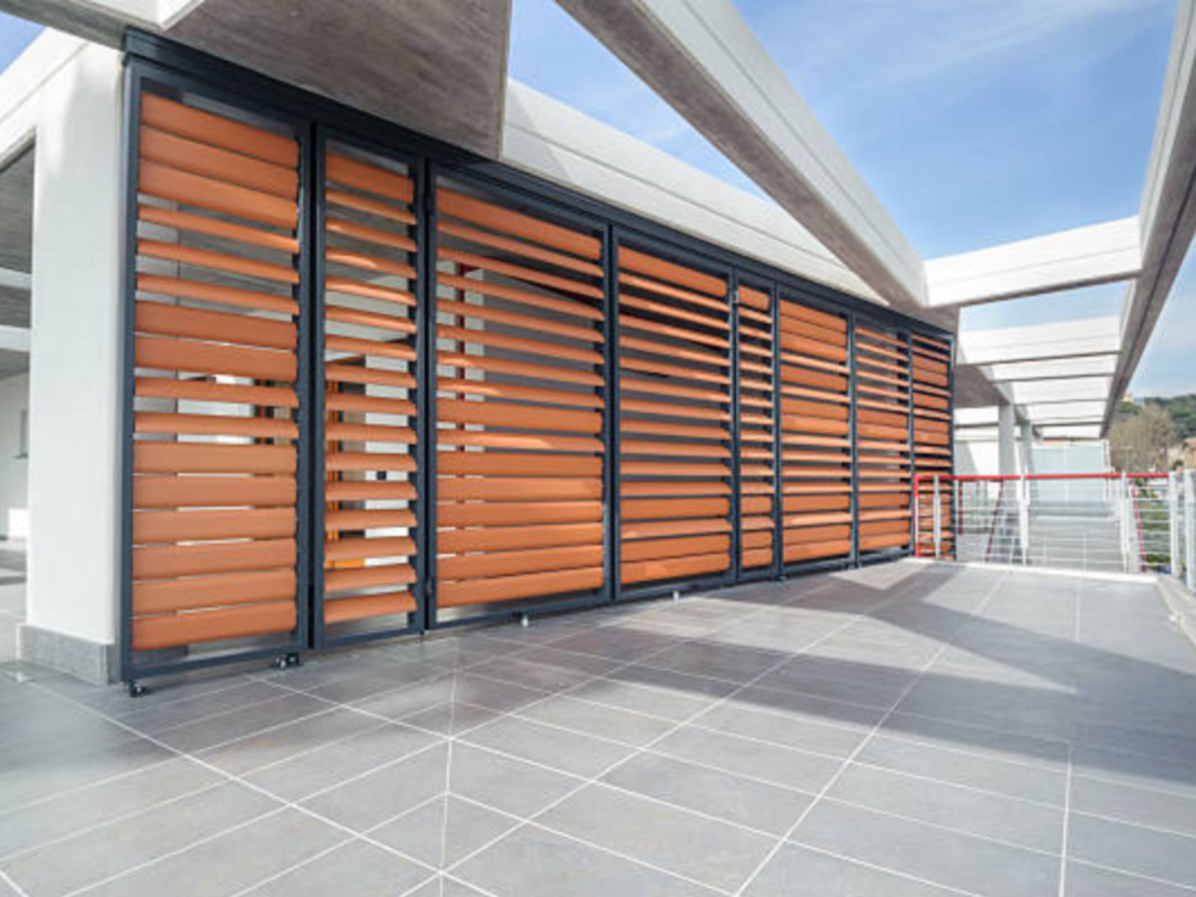 Modern penthouse with orange louver panels on the terrace.
