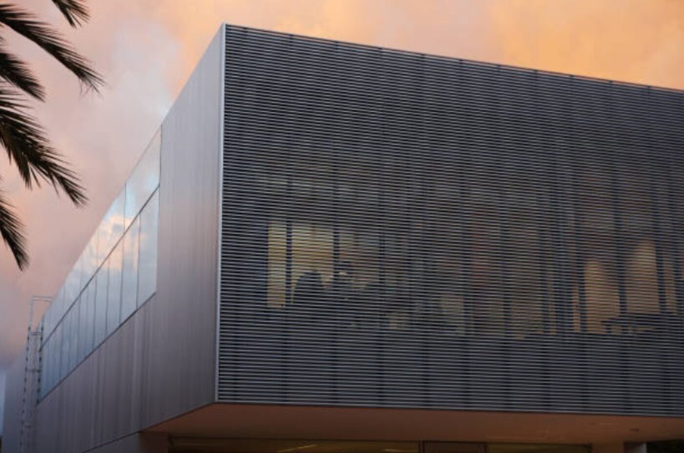 Modern commercial building wrapped in architectural metal cladding with horizontal metal panels and a sleek, minimalist facade.